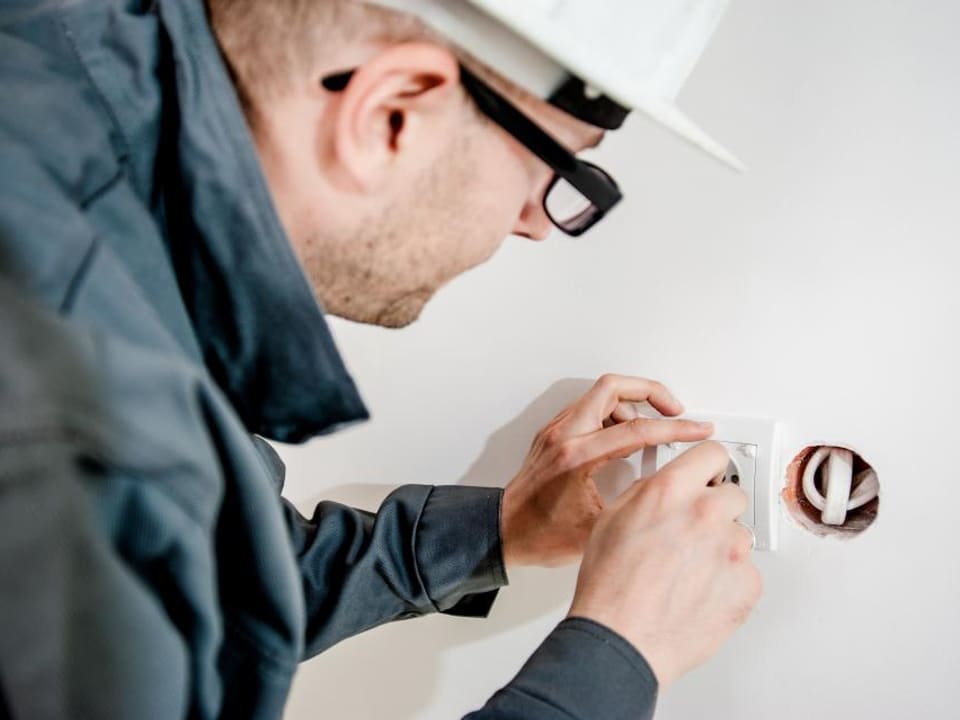 Elektricien aan het werk aan een verdeelbord (tijdelijke stockfoto)